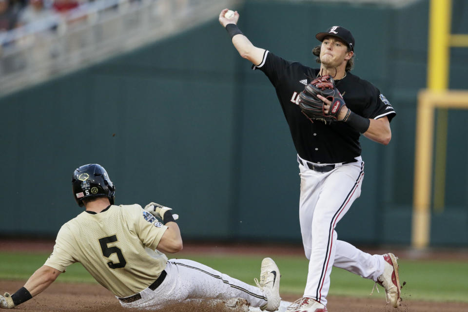 Louisville shortstop Tyler Fitzgerald throws to first to complete a double play after forcing out Vanderbilt's Philip Clarke (5), in the seventh inning of an NCAA College World Series baseball game in Omaha, Neb., Friday, June 21, 2019. Stephen Scott was out at first. (AP Photo/Nati Harnik)