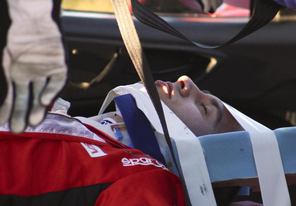 Matteo Malucelli, of Italy, is removed from his car after he was involved in a wreck during the IMSA Series Rolex 24 hour auto race at Daytona International Speedway in Daytona Beach, Fla., Saturday, Jan. 25, 2014.(AP Photo/Dow Graham)