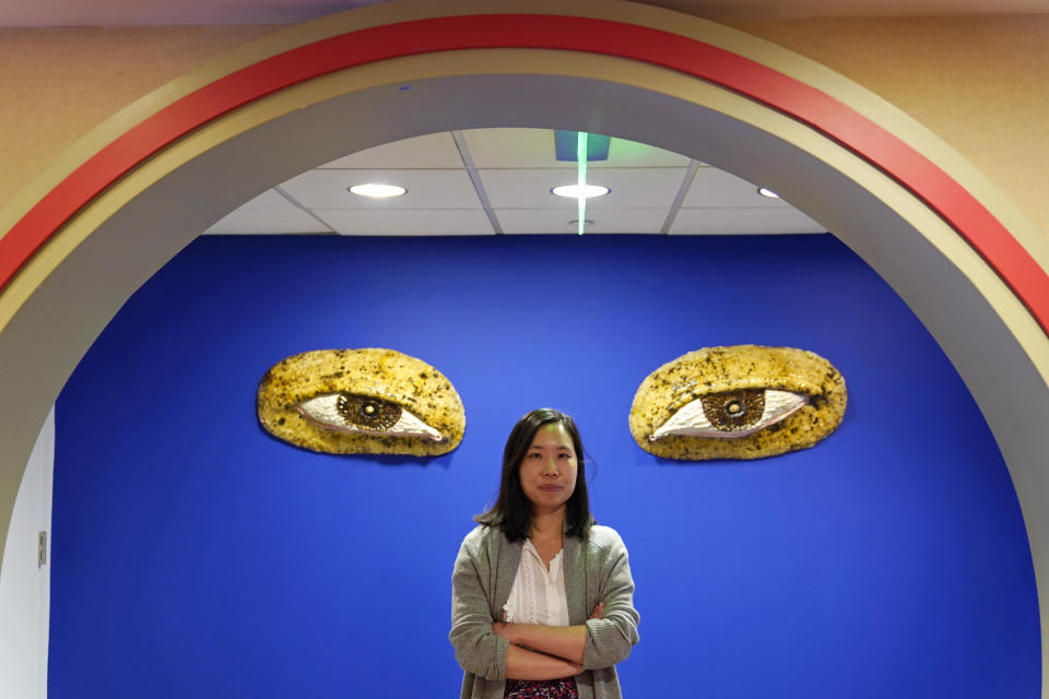 Jenny Leung, executive director of the Chinese Culture Center, poses by the entrance to the center's art gallery in San Francisco, May 23, 2022. Chinatowns and other Asian American enclaves across the U.S. are using art and culture to show they are safe and vibrant hubs. "It was really, really important that the community was empowered and centered as a voice in the art because I think frequently the way that Chinatown looks is imported as a tourist kind of attraction and fantasy for visitors to see," Leung said. "It's never really about celebrating the community's perspective and voice." (AP Photo/Eric Risberg)