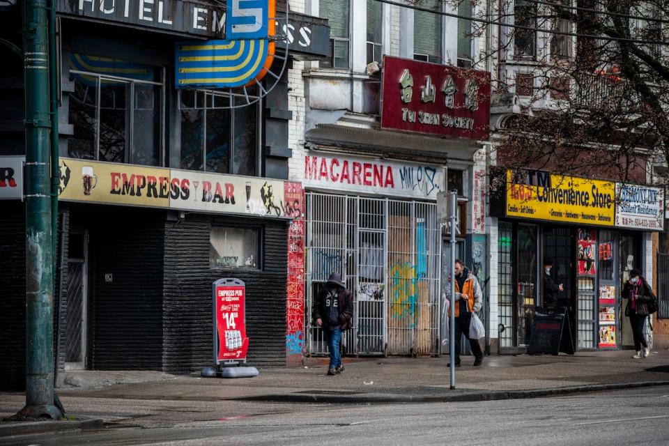 People walk along Hastings Street, near Main Street, in Vancouver's Downtown Eastside on Feb. 23, 2021. City council has passed a motion to look at expanding Wi-Fi access in the neighbourhood. (Ben Nelms/CBC - image credit)