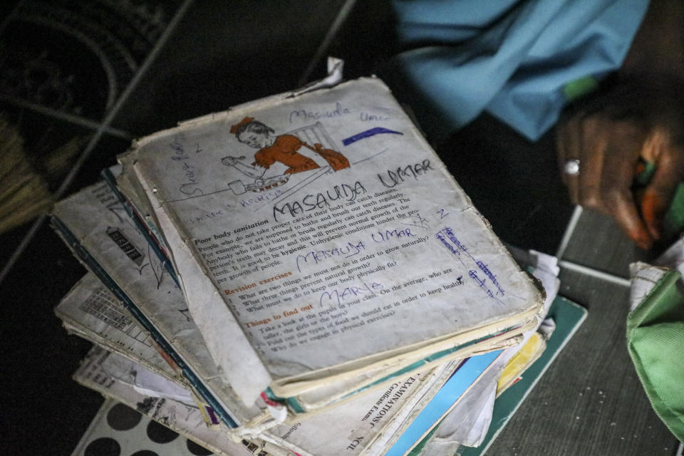 Schoolbooks sit next to Student Masauda Umar, 20, who hid under her bed and managed to escape when gunmen abducted more than 300 girls from her boarding school on Friday, as she recounts her ordeal at her house in Jangebe town, Zamfara state, northern Nigeria Saturday, Feb. 27, 2021. Nigerian police and the military have begun joint operations to rescue the more than 300 girls who were kidnapped from the Government Girls Junior Secondary School, according to a police spokesman. (AP Photo/Ibrahim Mansur)