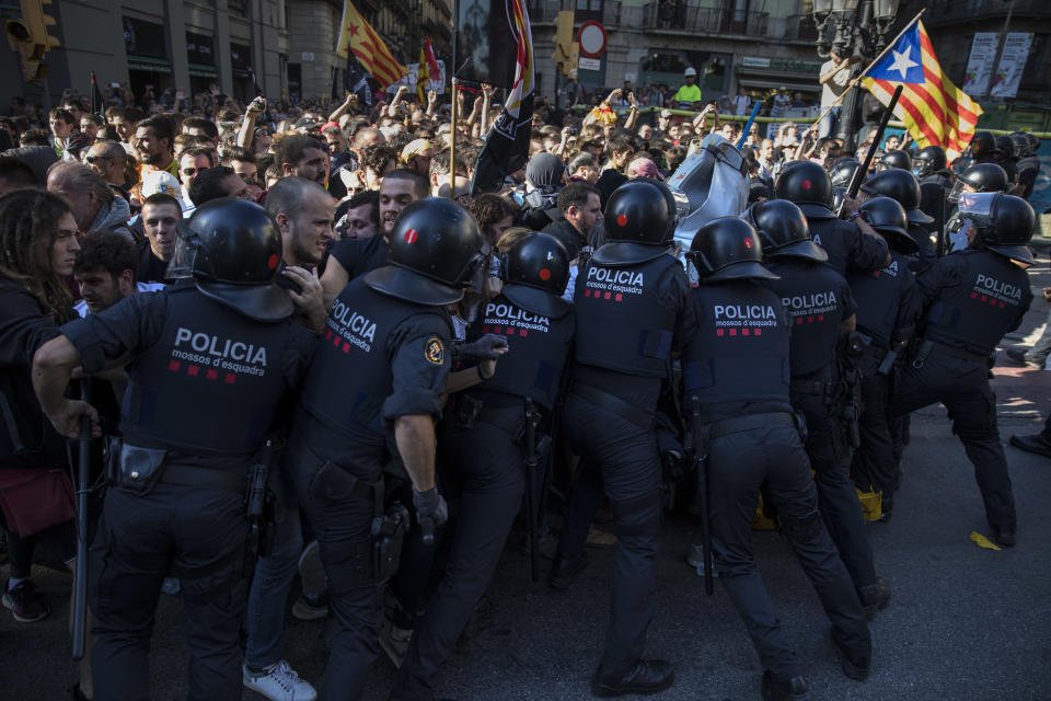 Catalan police officers clash with pro independence demonstrators on their way to meet demonstrations by members and supporters of National Police and Guardia Civil in Barcelona on Saturday, Sept. 29, 2018. (AP Photo/Emilio Morenatti)