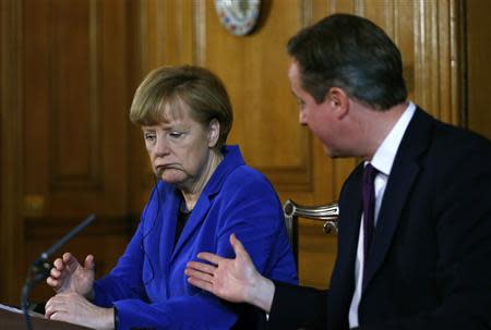 Britain's Prime Minister David Cameron hands over to German Chancellor Angela Merkel during a news conference at Number 10 Downing Street in London February 27, 2014. REUTERS/Andrew Winning