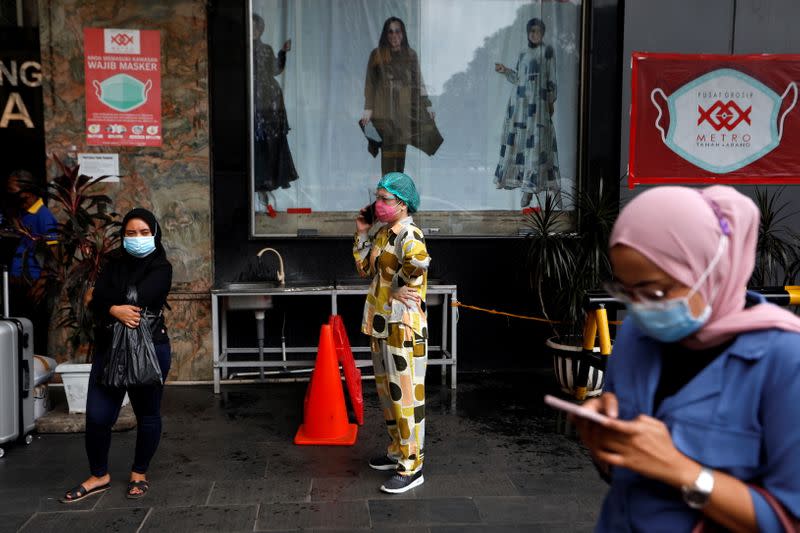 Women wearing protective masks following the outbreak of the coronavirus disease (COVID-19) stand outside a shopping mall at Tanah Abang textile market in Jakarta