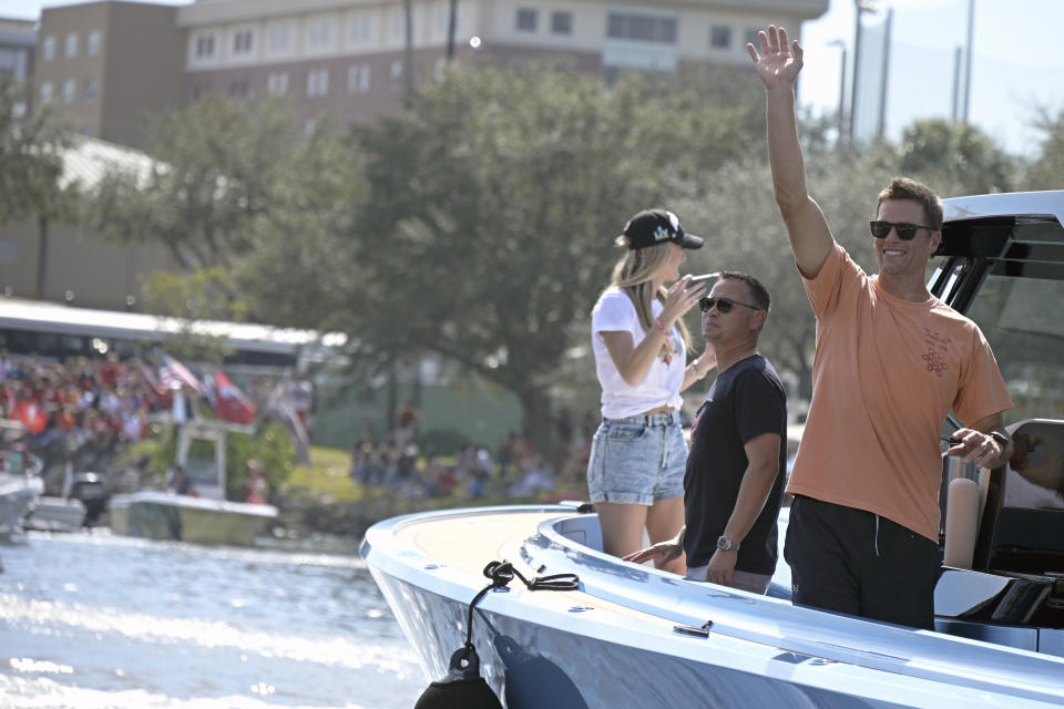 FILE - Tampa Bay Buccaneers NFL football quarterback Tom Brady waves to fans as he celebrates their Super Bowl 55 victory over the Kansas City Chiefs with a boat parade in Tampa, Fla., in this Wednesday, Feb. 10, 2021, file photo. Viewership in the Boston market topped that of the Tampa, Fla. market for last season's Super Bowl, and New England fans continue to tune in for Brady's games in droves through the first two weeks of this season. (AP Photo/Phelan Ebenhack, File)