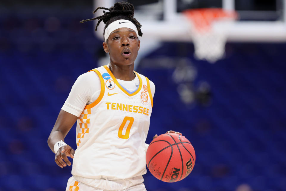 Rennia Davis with the ball in her hand dribbling. 