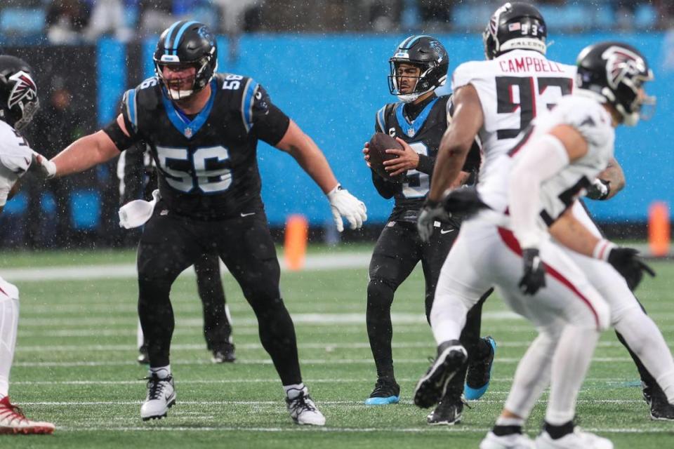 Panthers center Bradley Bozeman (56) defends the pocket as quarterback Bryce Young (9) scans the field for a pass during the game against the Falcons at Bank of America Stadium on Sunday, December 16, 2023.