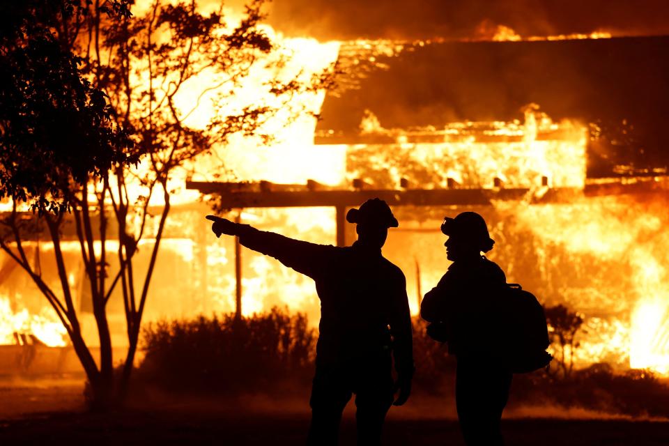 A firefighter gestures as Park Fire burns near Chico, California, U.S. July 25, 2024. REUTERS/Fred Greaves