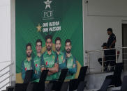 Pakistani police officers observes area next to portraits of Pakistani cricketer from an enclosure of the Pindi Cricket Stadium before the stat of the first one day international cricket match between Pakistan and New Zealand at the Pindi Cricket Stadium, in Rawalpindi, Pakistan, Friday, Sept. 17, 2021. The limited-overs series between Pakistan and New Zealand has been postponed due to security concerns of the Kiwis. (AP Photo/Anjum Naveed)