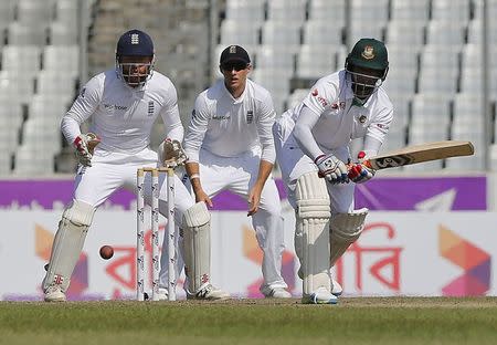 Cricket - Bangladesh v England - Second Test cricket match - Sher-e-Bangla Stadium, Dhaka, Bangladesh - 30/10/16. Bangladesh's Shakib Al Hasan (R) plays a shot as England's wicketkeeper Jonathan Bairstow (L) and Joe Root look on. REUTERS/Mohammad Ponir Hossain