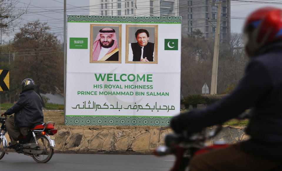 Pakistani motorcyclists pass by a billboard welcoming Saudi Arabia's Crown Prince Mohammed bin Salman displayed on the occasion of the visit by Saudi Arabia's crown prince to Pakistan, in Islamabad, Pakistan, Sunday, Feb. 17, 2019. Saudi Crown Prince Mohammed bin Salman will arrive in Islamabad on Sunday evening on an official visit that is expected to include the signing of agreements for billions of dollars of investment in Pakistan. (AP Photo/Anjum Naveed)