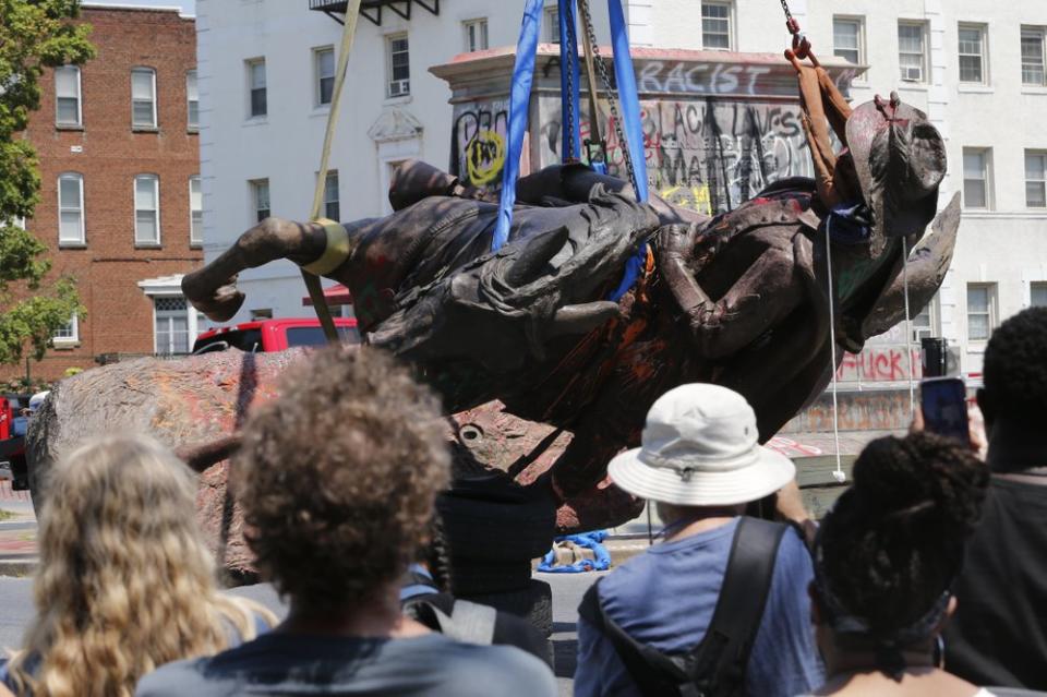 This Tuesday July 7, 2020, file photo shows crews at they lower the statue Confederate General J.E.B. Stuart in preparation for transport after removing it from its pedestal on Monument Avenue in Richmond, Va. (AP Photo/Steve Helber)