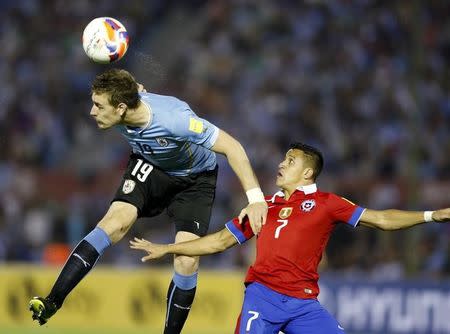 Uruguay's Sebastian Coates (L) heads the ball next to Chile's Alexis Sanchez during their 2018 World Cup qualifying soccer match at Centenario stadium in Montevideo, November 17, 2015. REUTERS/Andres Stapff