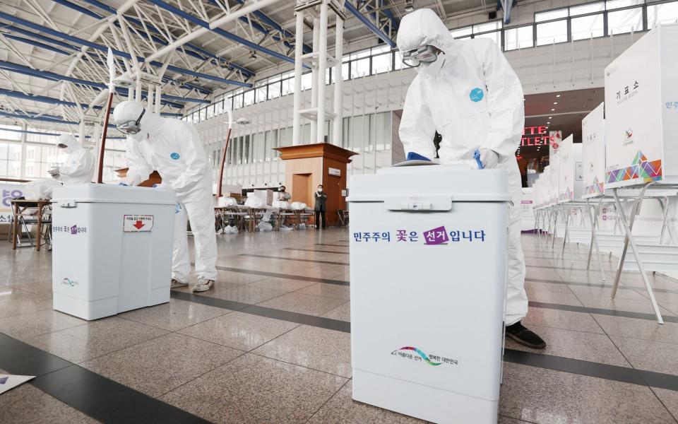  Quarantine workers disinfect ballot boxes amid the coronavirus COVID-19 pandemic at a polling station installed inside Seoul Station, one day ahead of two-day early voting for the April 7 Seoul mayoral by-election - YONHAP/EPA-EFE/Shutterstock 