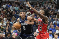 Orlando Magic forward Paolo Banchero (5) drives past Chicago Bulls guard Ayo Dosunmu (12) during the first half of an NBA basketball game, Sunday, April 7, 2024, in Orlando, Fla. (AP Photo/John Raoux)