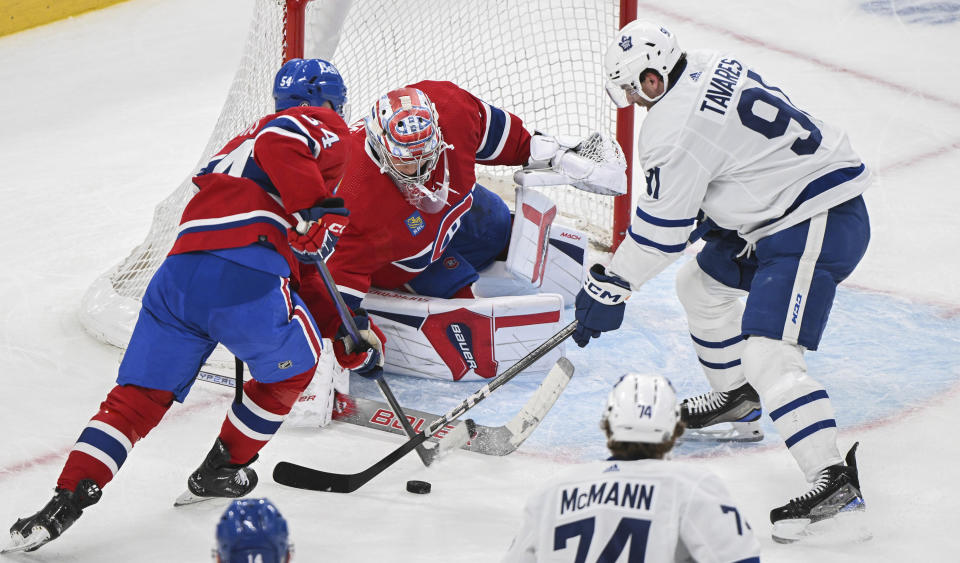 Toronto Maple Leafs' John Tavares (91) moves in on Montreal Canadiens goaltender Cayden Primeau as Canadiens' Jordan Harris (54) defends during the second period of an NHL hockey game Saturday, April 6, 2024, in Montreal. (Graham Hughes/The Canadian Press via AP)