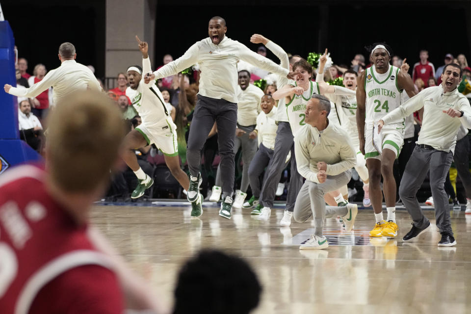 North Texas players and coaches celebrate after defeating Wisconsin in an NCAA college basketball game in the semifinals of the NIT, Tuesday, March 28, 2023, in Las Vegas. (AP Photo/John Locher)
