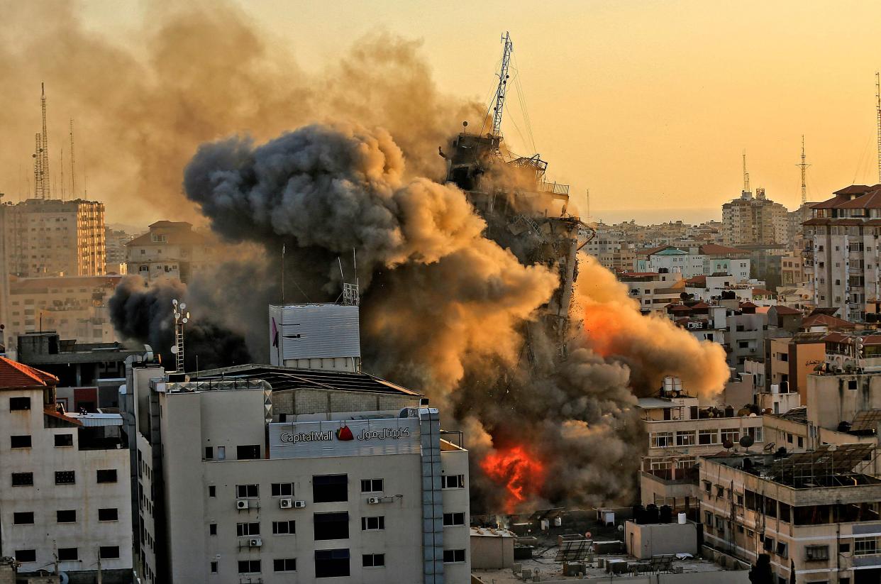 Heavy smoke and fire rise from Al-Sharouk tower as it collapses after being hit by an Israeli air strike, in Gaza City on May 12. 