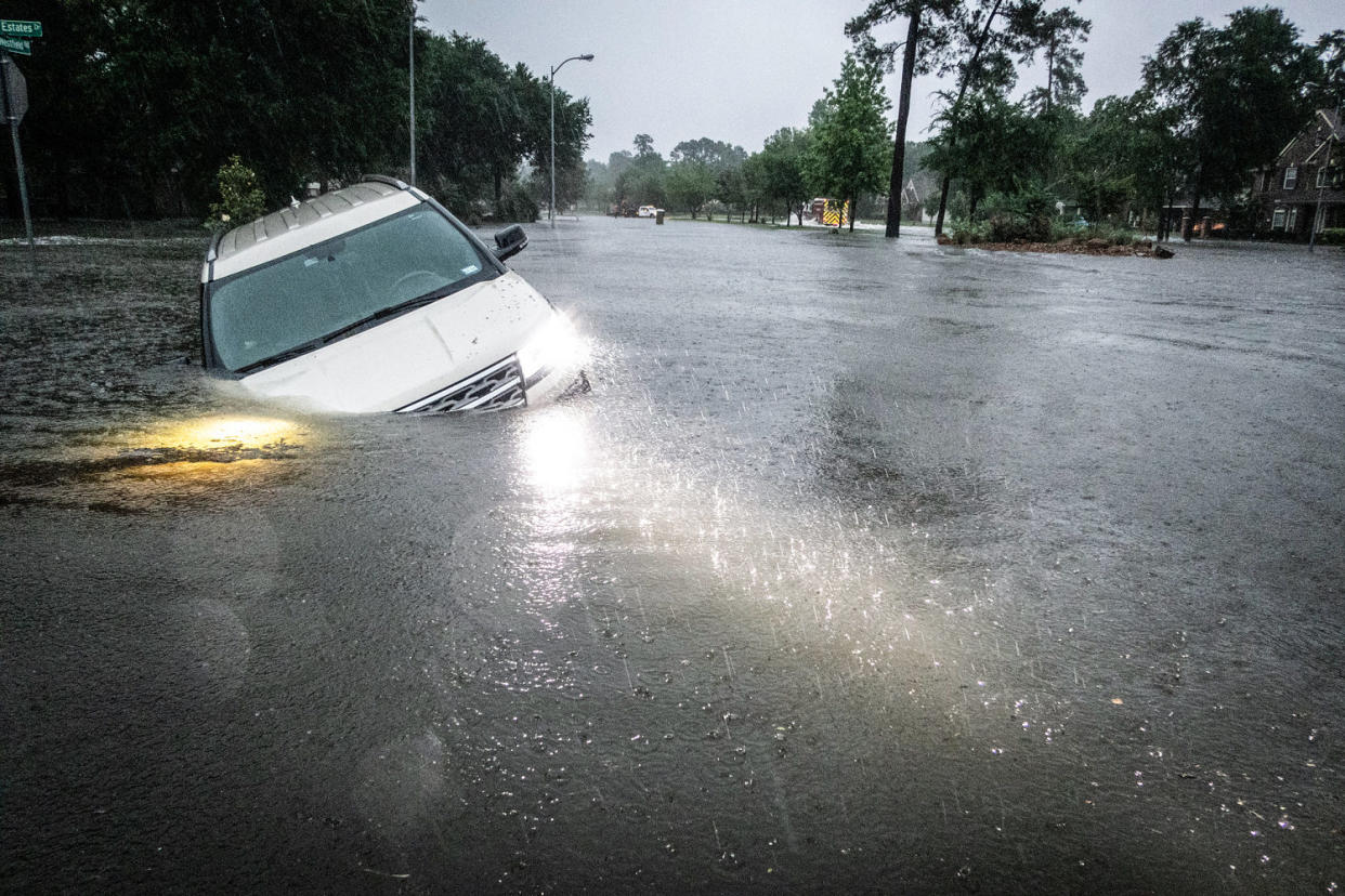 An empty car is caught in high flood waters in the rain (Brett Coomer / Houston Chronicle via Getty Images)