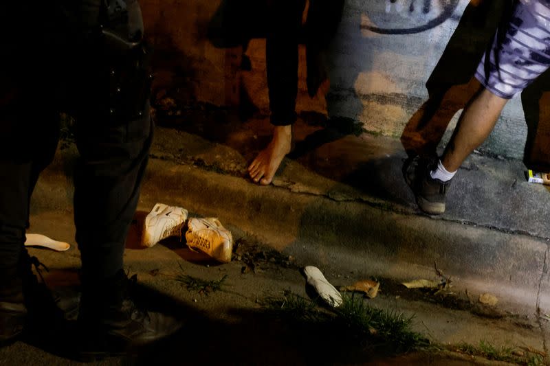 A police officer questions men while searching for drugs and weapons during the "Costa Rica Segura Plus" operation, in San Jose