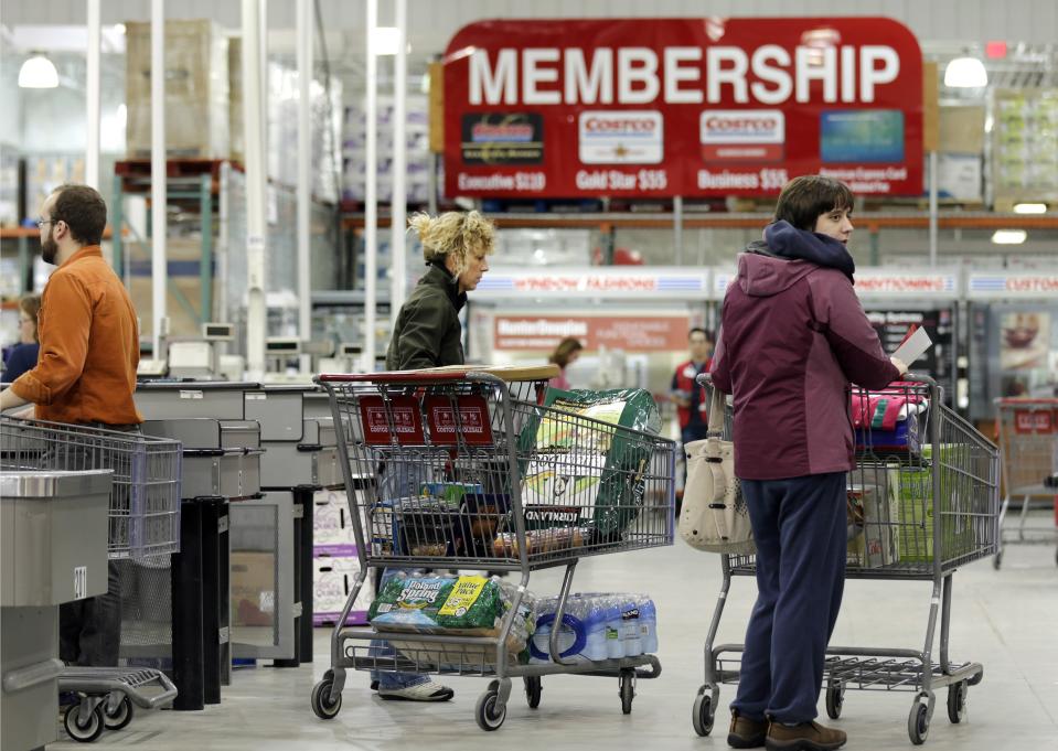 In this Tuesday, March 5, 2013, photo,  shoppers push their carts at the Costco store in Nashua, N.H. Costco's fiscal second-quarter net income climbed 39 percent as it pulled in more money from membership fees, sales improved and it recorded a large tax benefit. The wholesale club operator earned $547 million, or $1.24 per share, for the period ended Feb. 17. That compares with $394 million, or 90 cents per share, a year earlier.   (AP Photo/Charles Krupa)