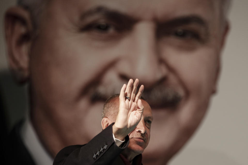 FILE-In this Tuesday, March 19, 2019 file photo, Turkey's President Recep Tayyip Erdogan, backdropped by a photo of his party's mayoral candidate for Istanbul, Binali Yildirim, addresses his supporters during a rally in Istanbul, ahead of local elections scheduled for March 31, 2019. For Turkish President Recep Tayyip Erdogan, Sunday’s local elections are about Turkey’s future national “survival.” After 17 years in office, the Turkish leader has a tight grip on power, but he is campaigning hard for the strong mandate that he says he needs to protect Turkey against threats from domestic and foreign enemies. Analysts say the rhetoric is aimed at diverting attention away from rising inflation, a sharp increase in food prices and high unemployment. (AP Photo/Emrah Gurel, File)