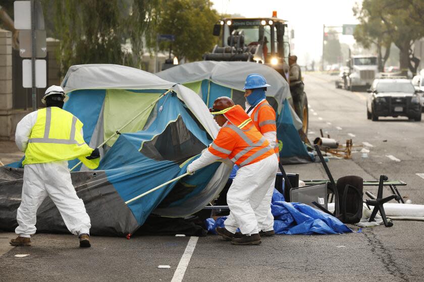 LOS ANGELES, CA - NOVEMBER 01: Members of the clean-up crew dismantled tents located on the Veterans Row homeless encampment along San Vicente Blvd just outside the West Los Angeles Veterans Affairs campus on Monday morning. A variety of organizations with the support of LA County Sheriff officers helped homeless veterans pack up to leave their encampment and move onto the West Los Angeles Veterans Affairs campus located behind a fence of their San Vicente Blvd camp on Monday morning. The encampment, adjacent to the historic VA campus has become a focal point for homelessness in the city, with mayoral candidates making visits over the last year. Veteran Affairs Secretary Denis McDonough, who visited the encampment in October, said that the roughly 40 veterans from Veterans Row would be housed by November. VA campus San Vicente Blvd on Monday, Nov. 1, 2021 in Los Angeles, CA. (Al Seib / Los Angeles Times).