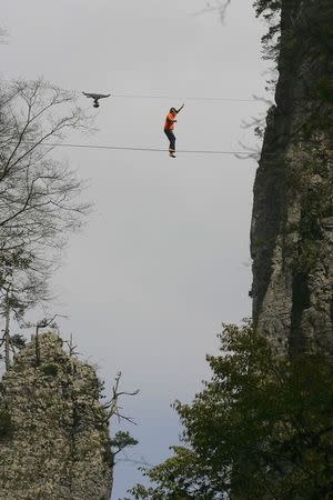 American climber Dean Potter walks barefooted on a rope which is connected between two mountain peaks in Enshi, Hubei province April 22, 2012. REUTERS/China Daily