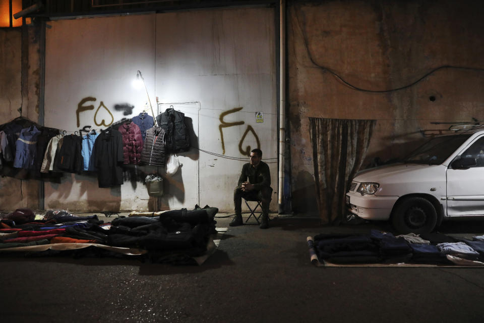 A street vendor waits for customer while selling clothes in southwestern Tehran, Iran, Tuesday, Nov. 2, 2021. As U.S. sanctions and the coronavirus pandemic wreak havoc on Iran's economy, suicides in the country increased by over 4%, according to a government study cited by the reformist daily Etemad. About 1 million Iranians have lost their jobs, and unemployment has climbed over 10% — a rate that is nearly twice as big among youths. (AP Photo/Vahid Salemi)