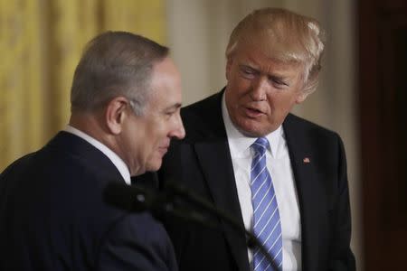 U.S. President Donald Trump (R) looks to Israeli Prime Minister Benjamin Netanyahu hold a joint news conference at the White House in Washington, U.S., February 15, 2017. REUTERS/Carlos Barria