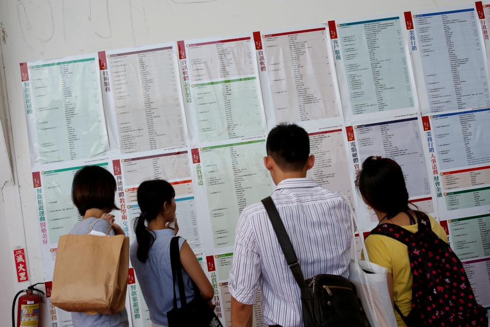 Job seekers look at job information at an employment fair in Taipei, Taiwan on May 28, 2016.