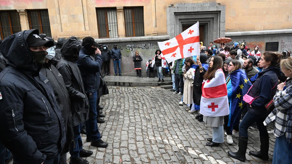 Georgian demonstrators stand in front of law enforcement officers blocking an area near the country's parliament building in Tbilisi on May 14. - Vano Shlamov/AFP/Getty Images