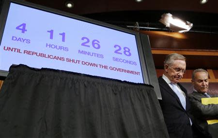 U.S. Senate Majority Leader Harry Reid (L) and Senator Charles Schumer stand next to a countdown clock while they discuss the potential U.S. government shutdown in four days, on Capitol Hill in Washington September 26, 2013. REUTERS/Larry Downing