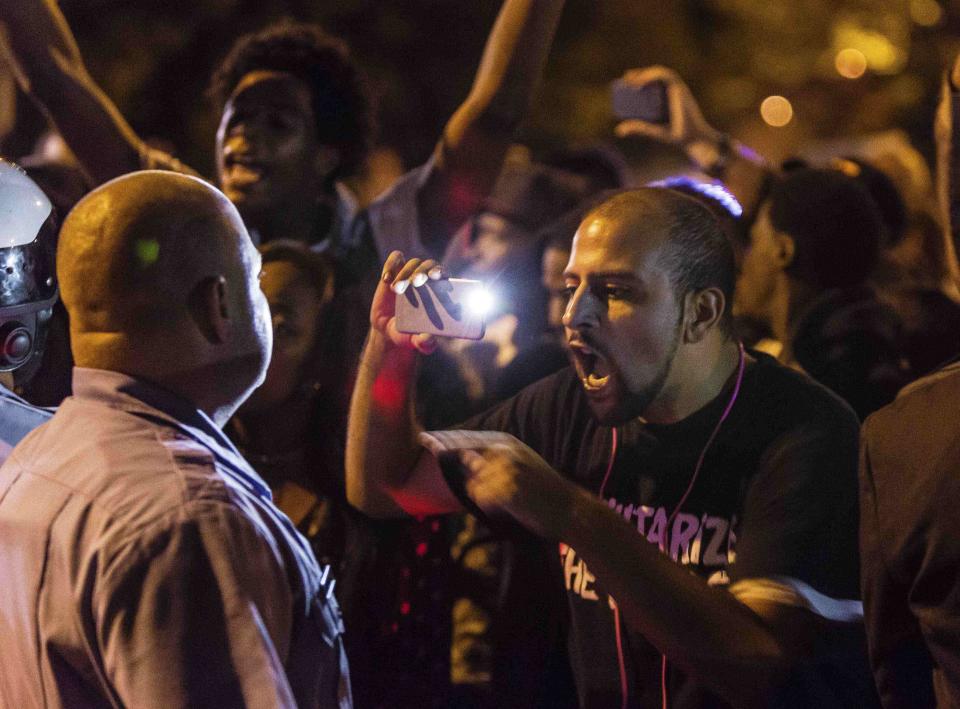 Demonstrator Bassem Masri confronts a St. Louis Metropolitan Police officer in St. Louis, Missouri October 8, 2014, during protests following an incident in which a white off-duty policeman shot and killed a black teenager. (REUTERS/Kenny Bahr)