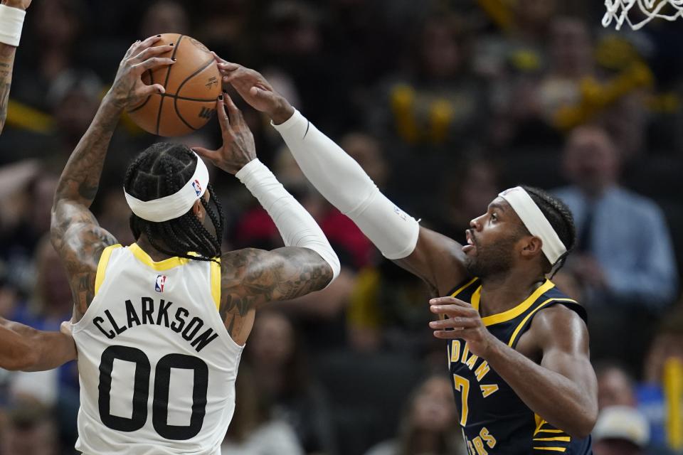 Indiana Pacers' Buddy Hield (7) knocks the ball out of the hands of Utah Jazz's Jordan Clarkson (00) during the first half of an NBA basketball game, Wednesday, Nov. 8, 2023, in Indianapolis. (AP Photo/Darron Cummings)