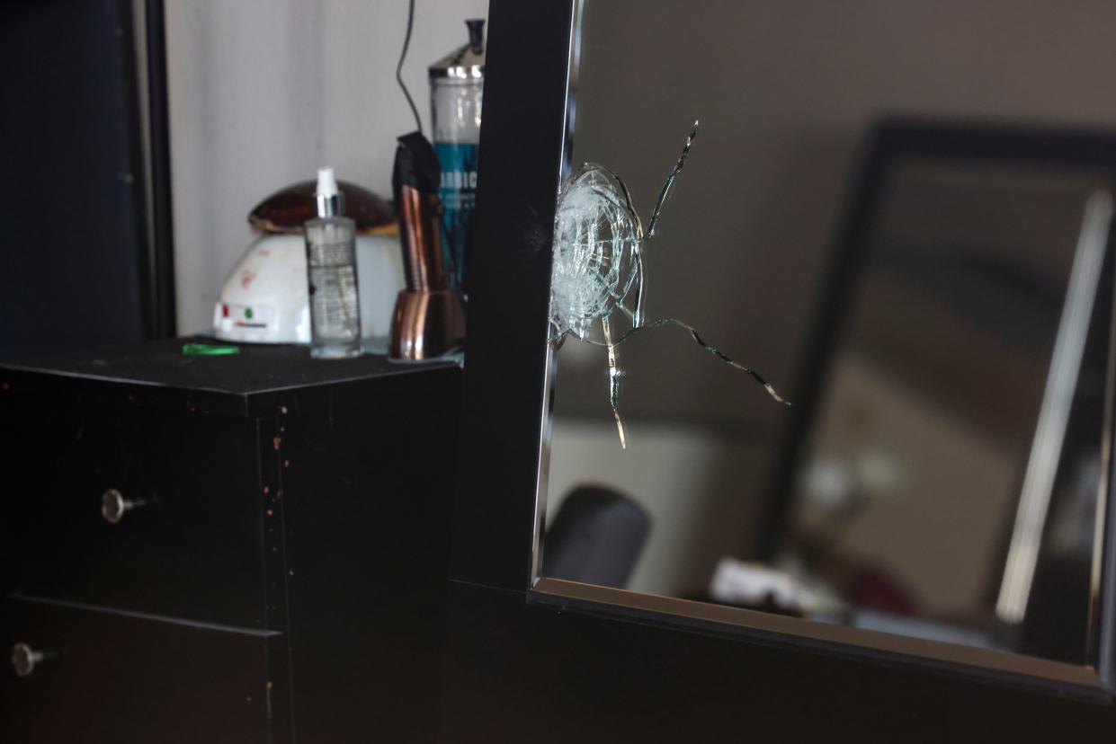 This photo shows a shattered mirror inside Hair World Salon.