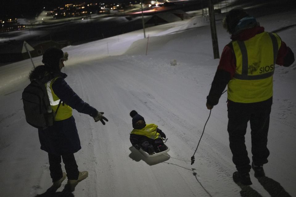 Neelu Singh and Shridhar Jawak walk home with their daughter Svalbie after a service at Svalbard Kirke in Longyearbyen, Norway, Sunday, Jan. 8, 2023. "You feel connected with the community and get a chance to be social," said Singh, who believes hers was the only Indian family in Longyearbyen when they moved here four years ago. (AP Photo/Daniel Cole)