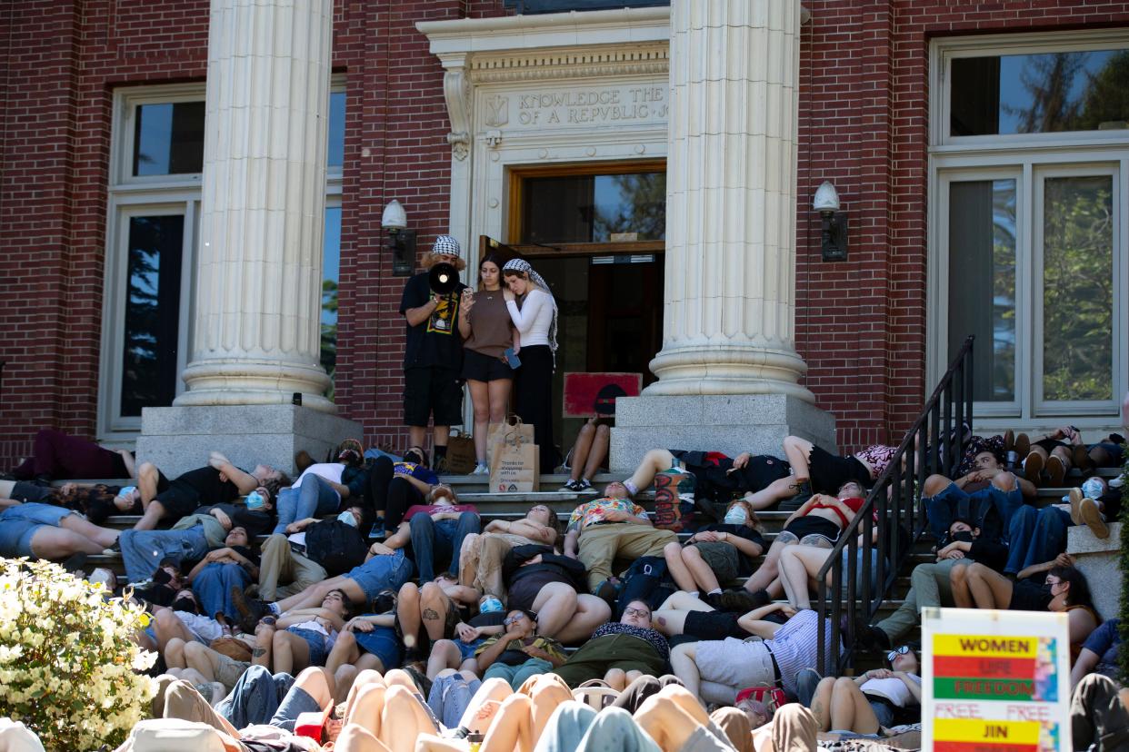 Pro-Palestinian protestors stage a die-in on the steps of Johnson Hall on the University of Oregon campus Friday, May 10, 2024, in support of a cease-fire in Gaza.
