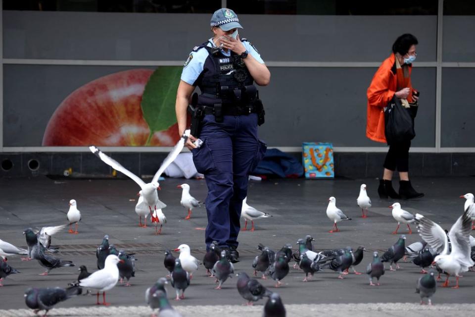 A police officer adjusts her face mask during a patrol in the central business district of Sydney.