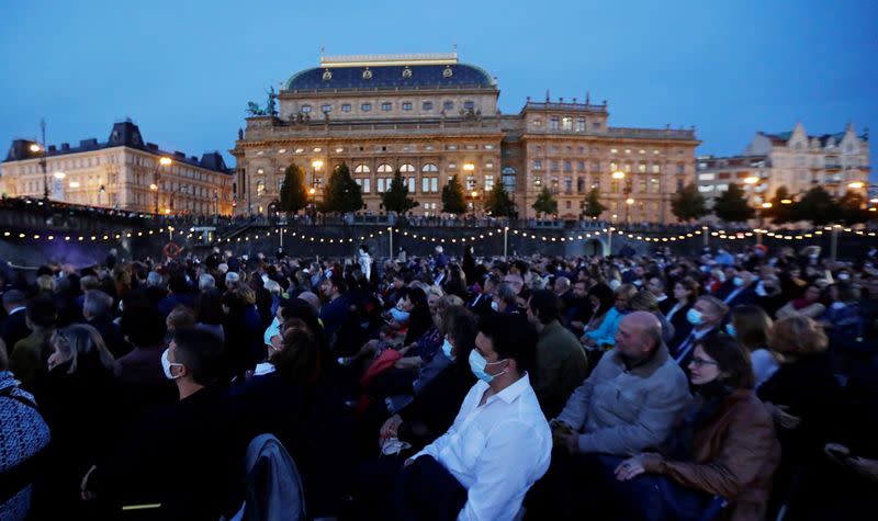 People watch a classical concert on a floating stage in Prague