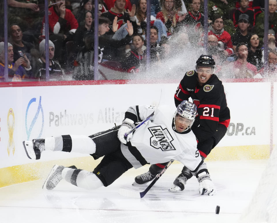Los Angeles Kings center Quinton Byfield (55) falls to the ice as he chases the puck against Ottawa Senators right wing Mathieu Joseph (21) during the second period of an NHL hockey game Thursday, Nov. 2, 2023, in Ottawa, Ontario. (Sean Kilpatrick/The Canadian Press via AP)