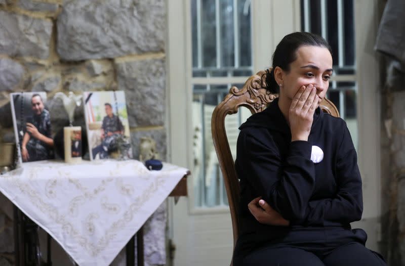 Karlin, wife of a firefighter Charbel Karam and sister of firefighter Najib Hitti, looks on, during an interview with Reuters in Qartaba