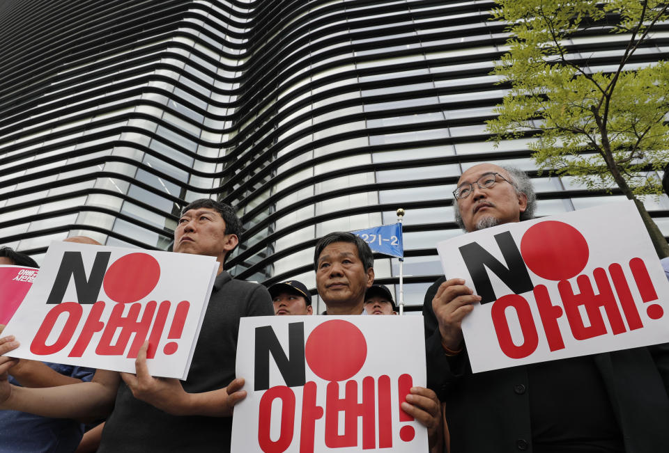 South Korean protesters hold signs during a rally denouncing the Japanese Prime Minister Shinzo Abe in front of the Japanese embassy in Seoul, South Korea, Thursday, Aug. 8, 2019. The letters read "No, Abe." (AP Photo/Lee Jin-man)