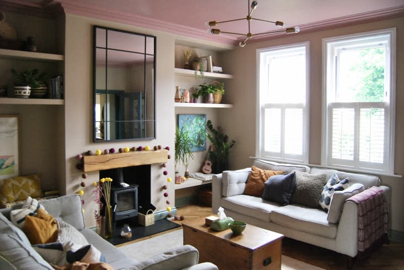 Living room with pink ceiling, large rectangular mirror, and matching grey couches.