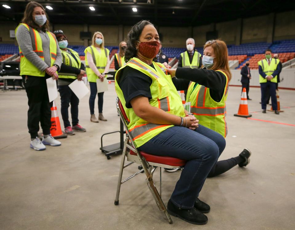 Atkinson Elementary special education teacher Tonya Moore, who works at Jefferson County Public Schools in Louisville, Kentucky, gets vaccinated by volunteer Laura Kinney at Broadbent Arena on Jan. 22, 2021.