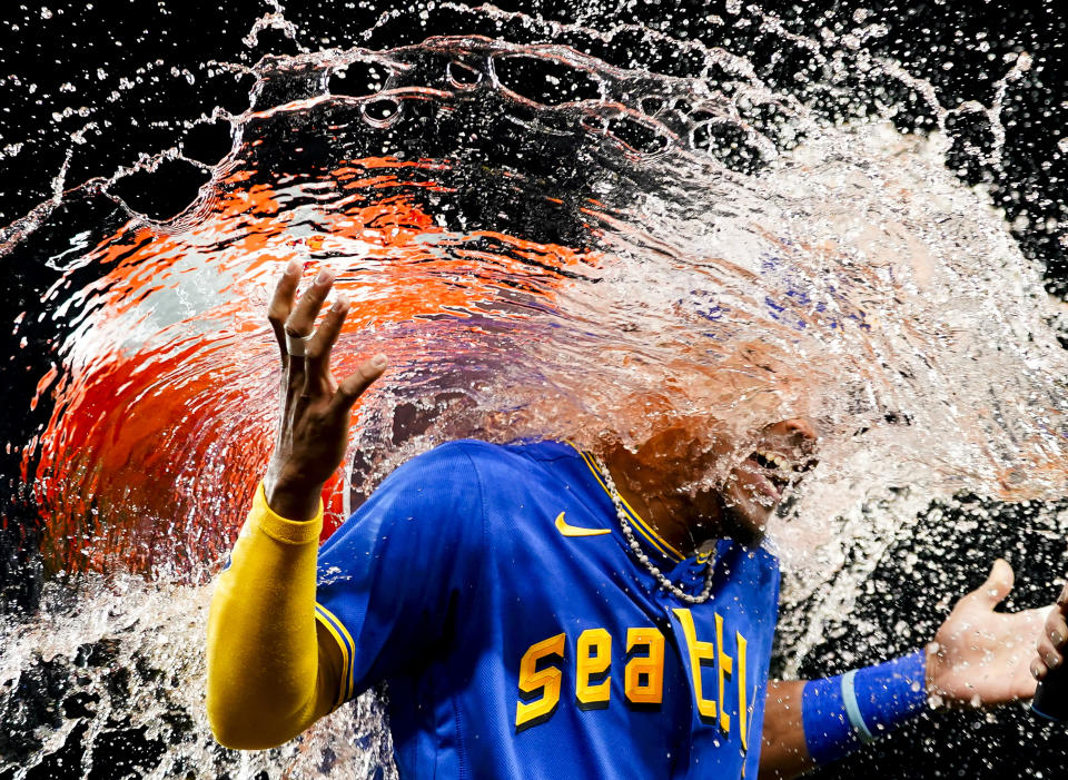 Seattle Mariners center fielder Julio Rodríguez laughs as teammate Teoscar Hernández douses him as they celebrate a 9-2 win over the Baltimore Orioles in a baseball game Friday, Aug. 11, 2023, in Seattle. (AP Photo/Lindsey Wasson)