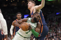 Boston Celtics guard Jaylen Brown (7) drives as New York Knicks center Isaiah Hartenstein, right, defends during the first half of an NBA basketball game Thursday, Jan. 26, 2023, in Boston. (AP Photo/Steven Senne)