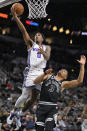 Sacramento Kings' Malik Monk (0) goes to the basket against San Antonio Spurs' Keldon Johnson during the first half of an NBA basketball game, Wednesday, Feb. 1, 2023, in San Antonio. (AP Photo/Darren Abate)