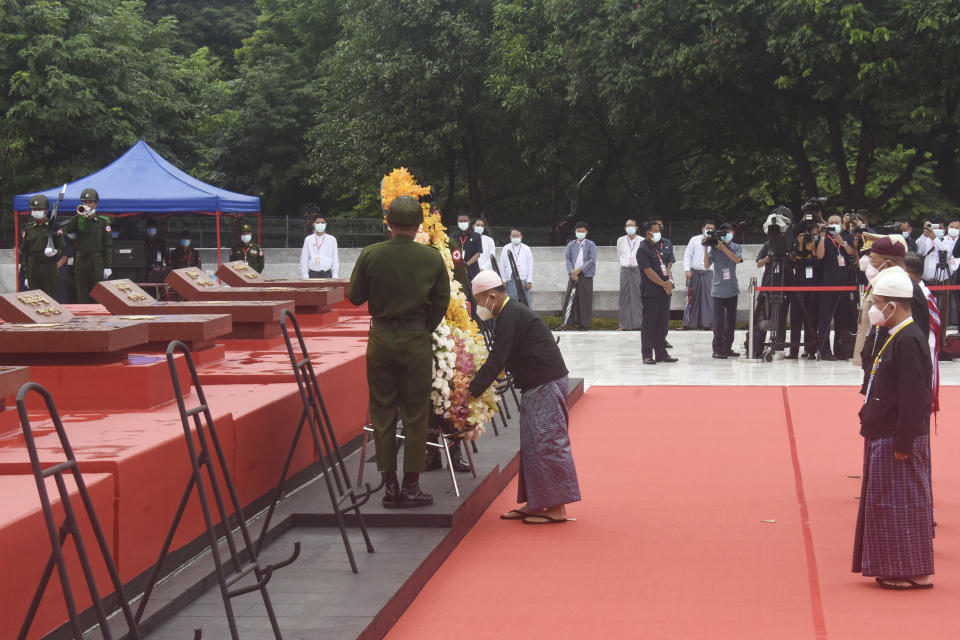 In this handout image provided by the Myanmar Ministry of Information, Vice-Senior Gen. Soe Win, center, vice-chairman of the military council, lays flower wreath at the tomb of Myanmar's independence hero Gen. Aung San during a ceremony to mark the 75th anniversary of his 1947 assassination, at the Martyrs' Mausoleum Tuesday, July 19, 2022, in Yangon, Myanmar. Myanmar's military-ruled government and its opponents on Tuesday marked the 75th anniversary of the assassination of independence hero Gen. Aung San, the father of the country's ousted leader, Aung San Suu Kyi. (Myanmar Ministry of Information via AP)
