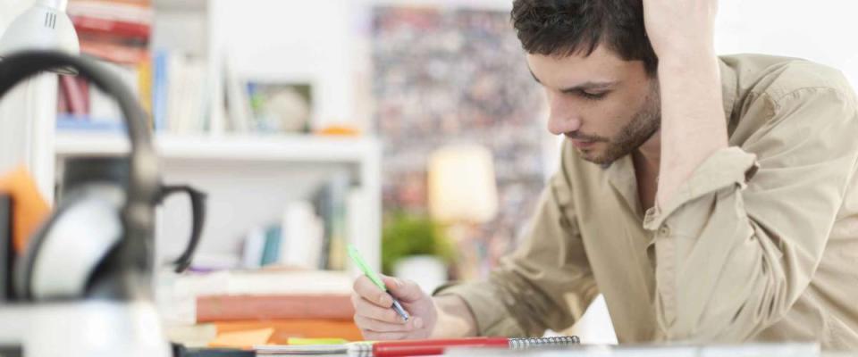 young student sitting at his desk and taking notes